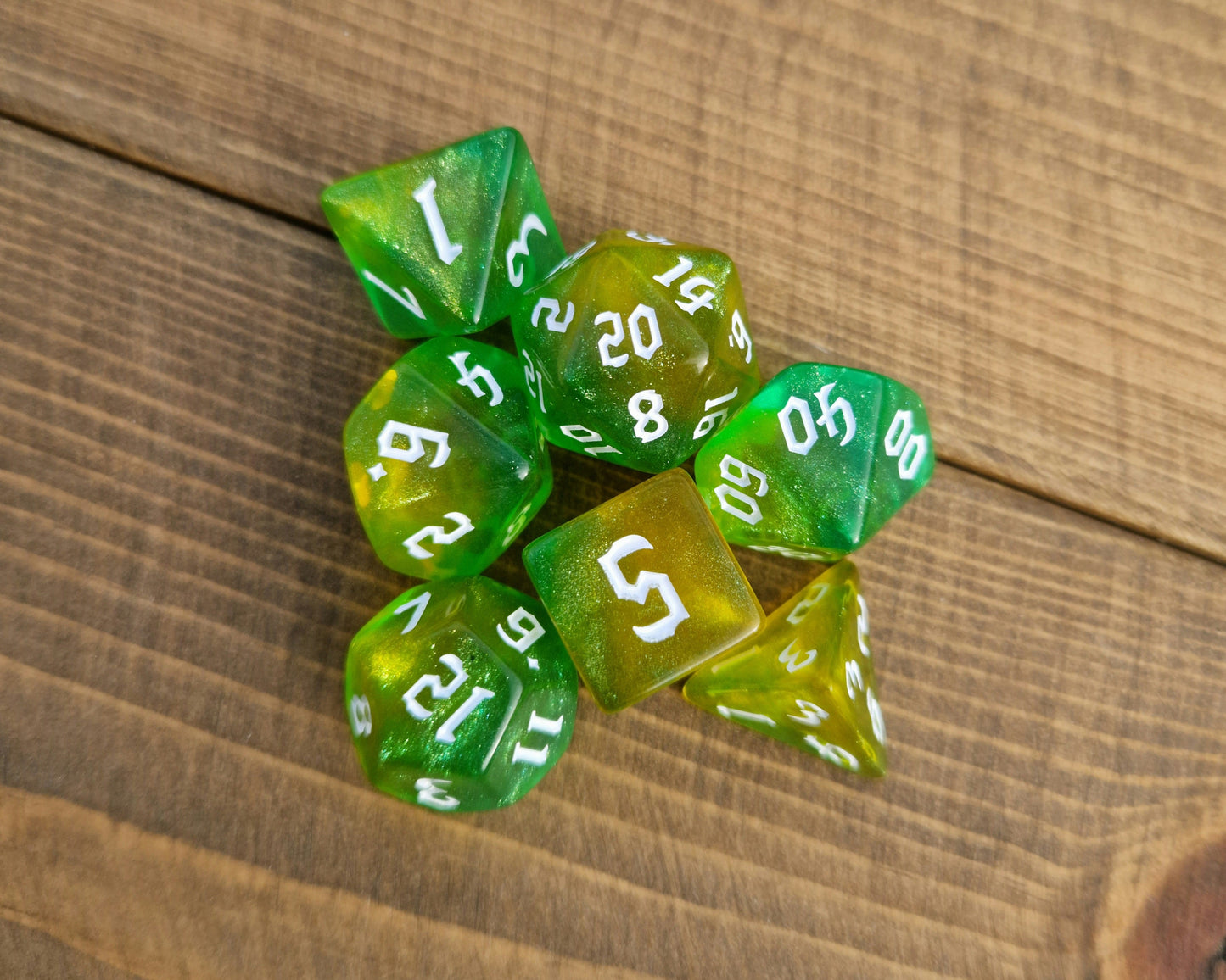 Shimmering green and yellow polyhedral dice with white numbers