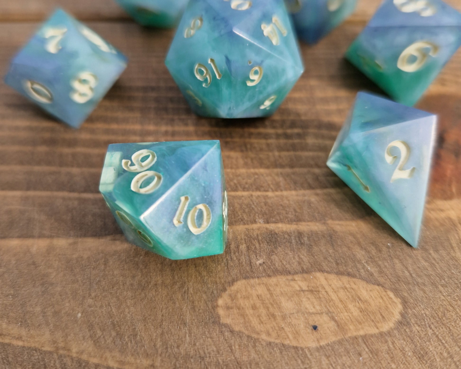 Hand crafted resin dice in green, blue and cream with bone coloured numbers