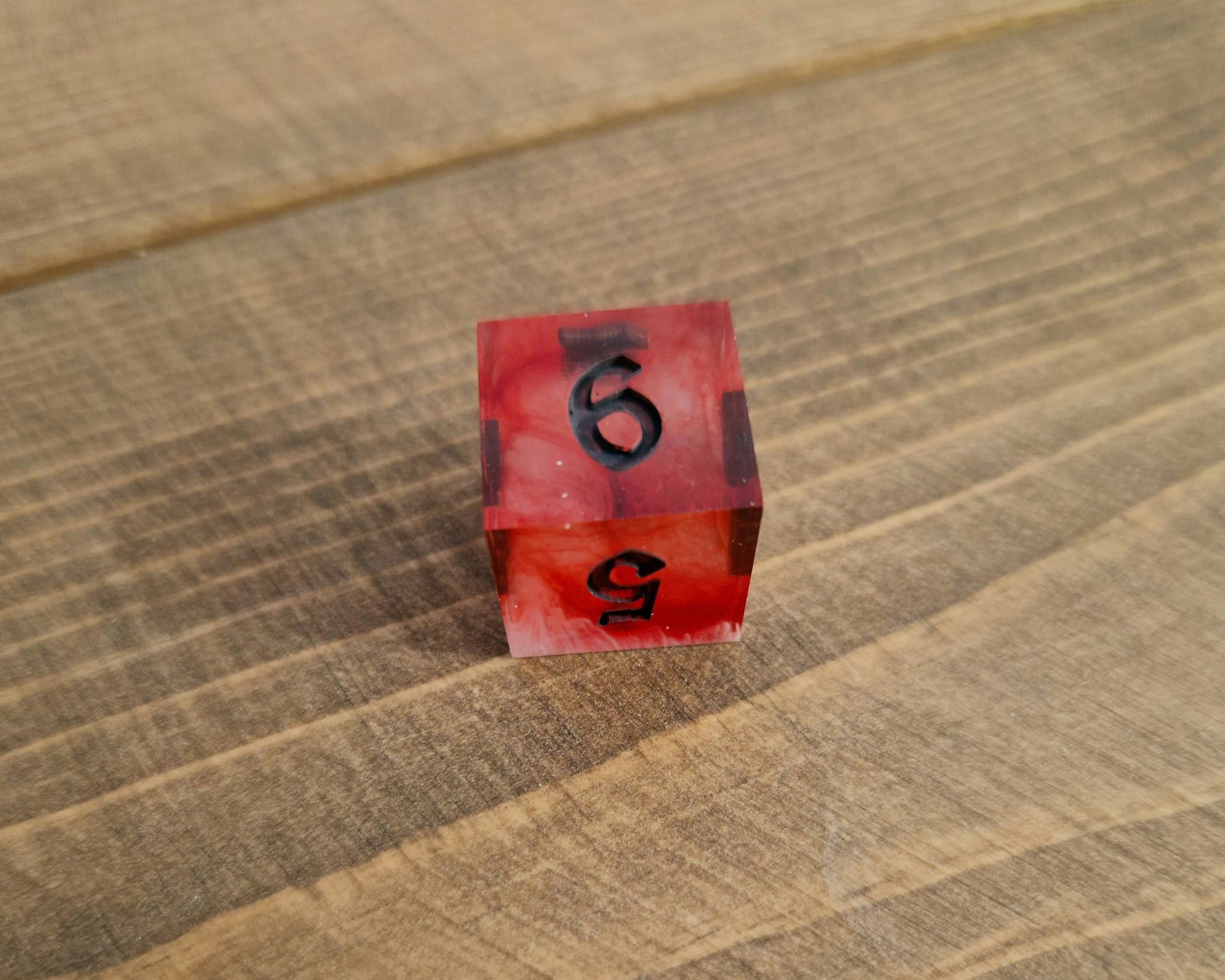 Red and white sharp resin dice with black numbers