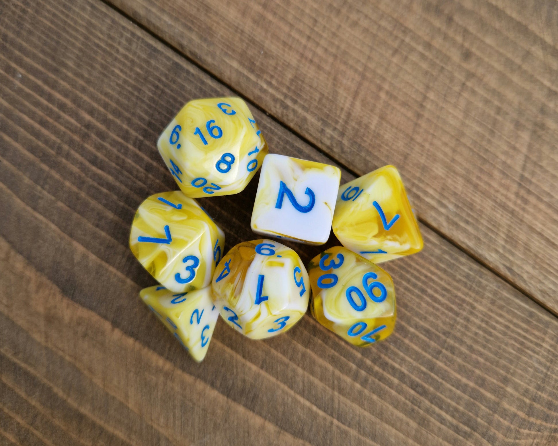yellow and white polyhedral dice set with blue numbers