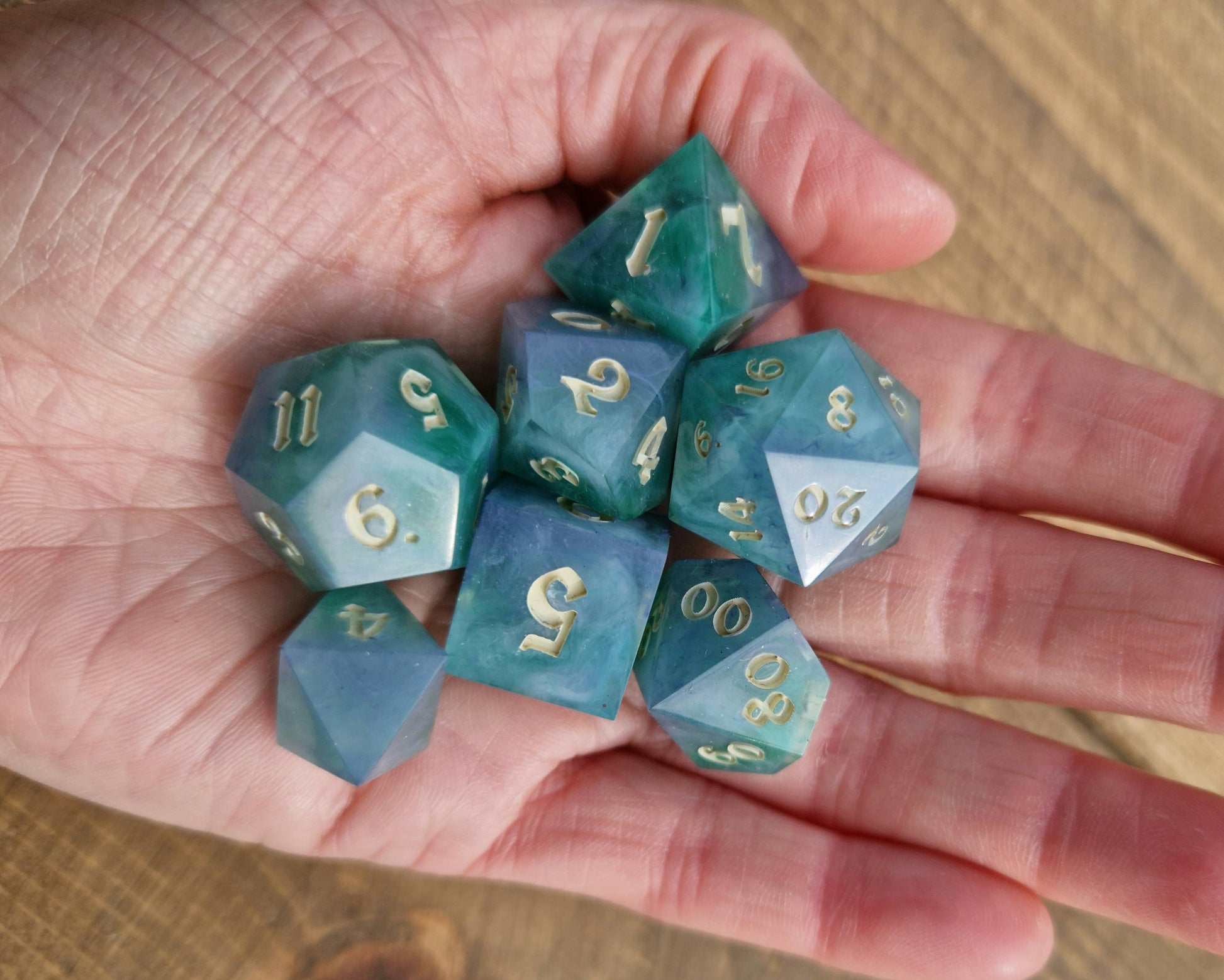 Hand crafted resin dice in green, blue and cream with bone coloured numbers