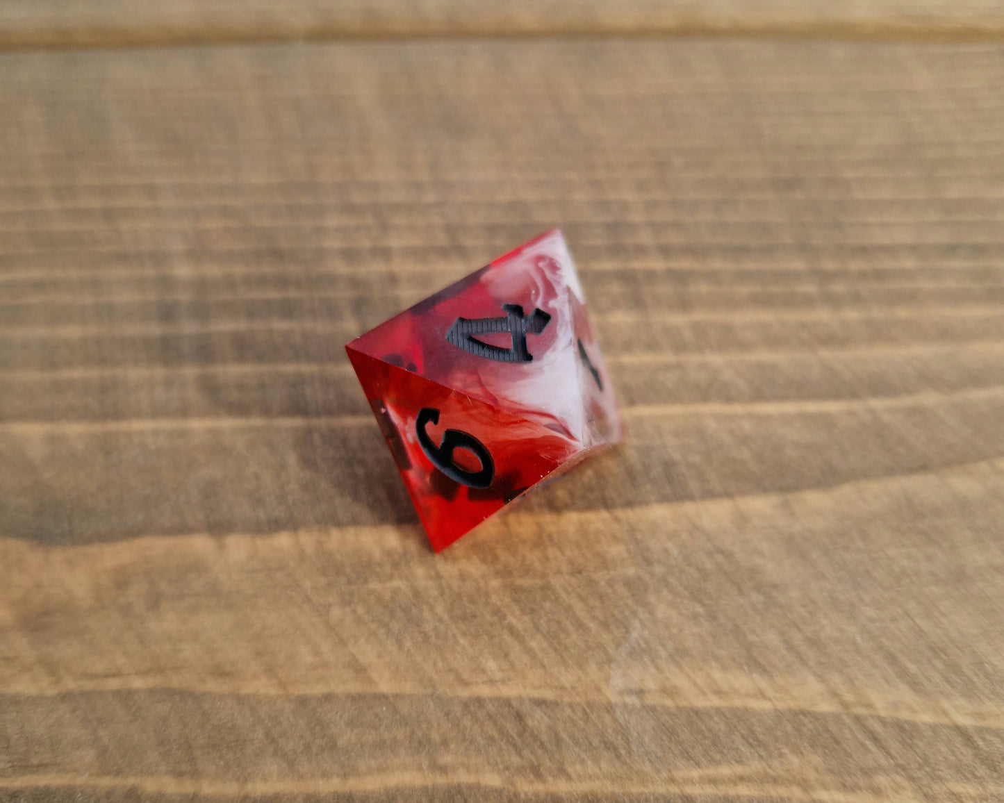 Red and white sharp resin dice with black numbers