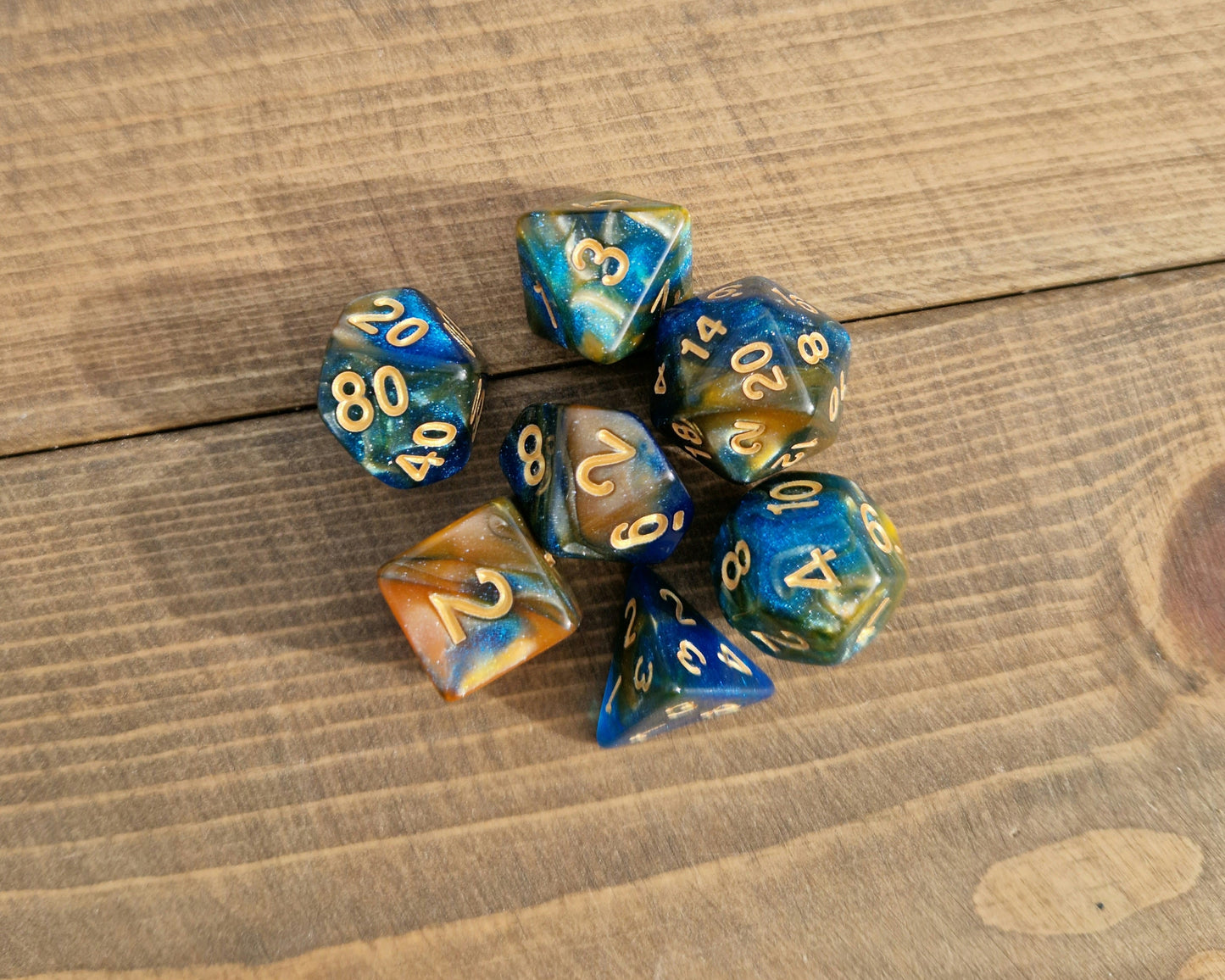 plastic polyhedral dice set in blue and gold shimmer swirl with gold numbers