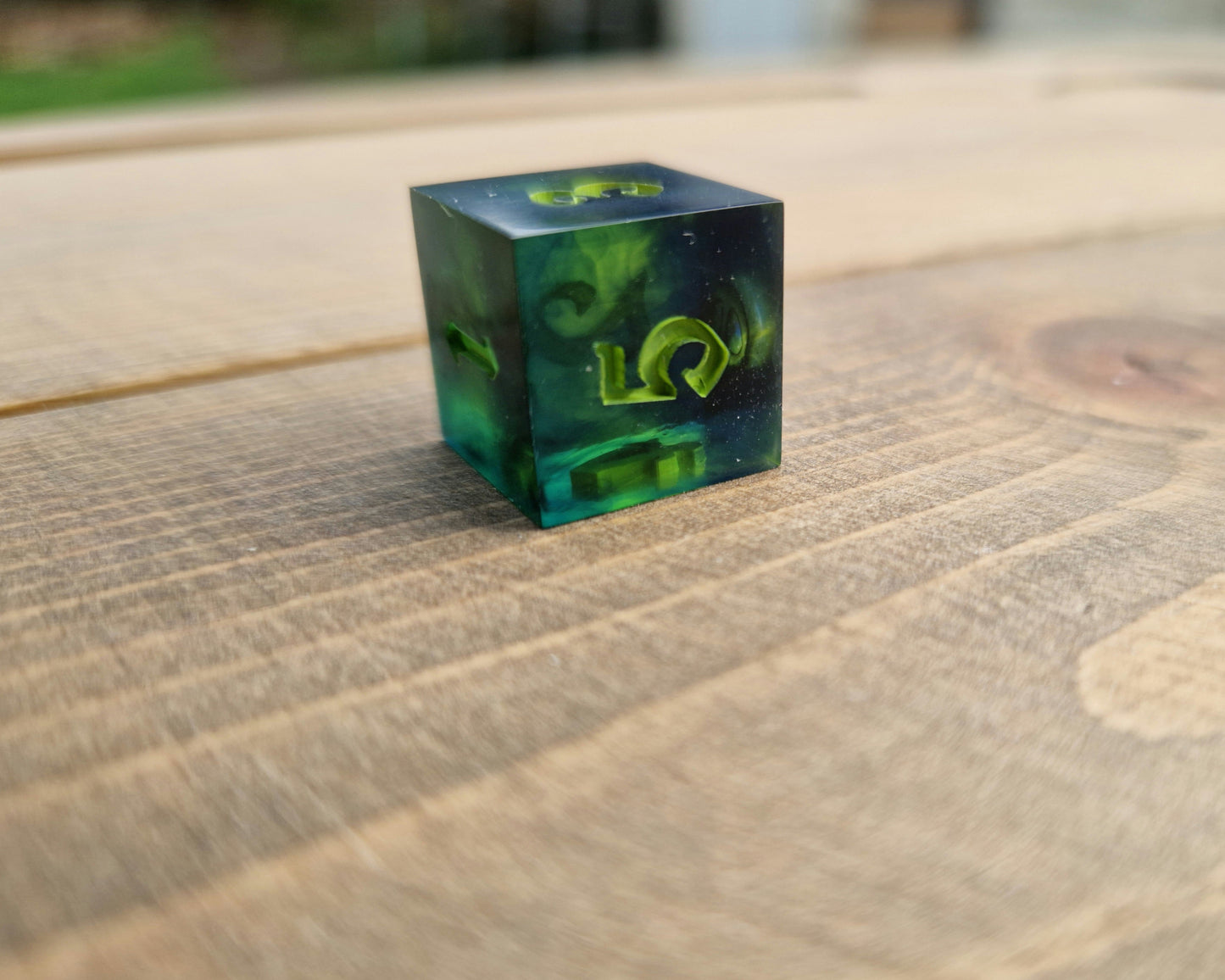 Dark green resin dice with bright green numbers
